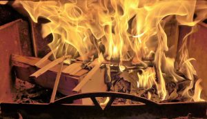 Allumage d’un feu dans un poêle à bois avec petit bois et papier